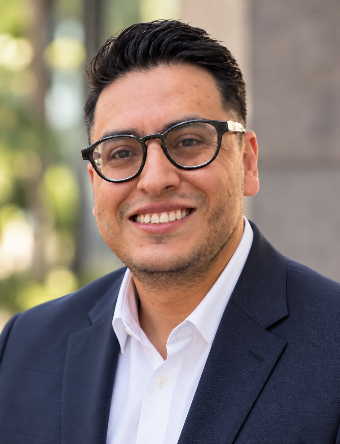 Pedro Arroyocastro wearing a navy blazer and glasses.